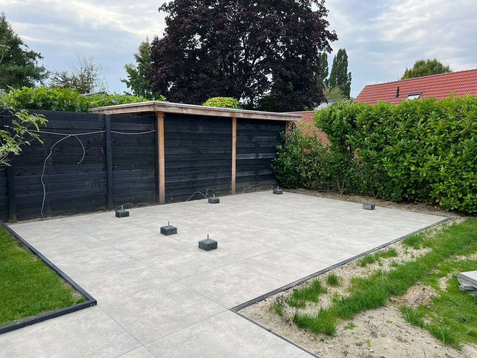 Terras met overkapping en een strak afgezet gazon