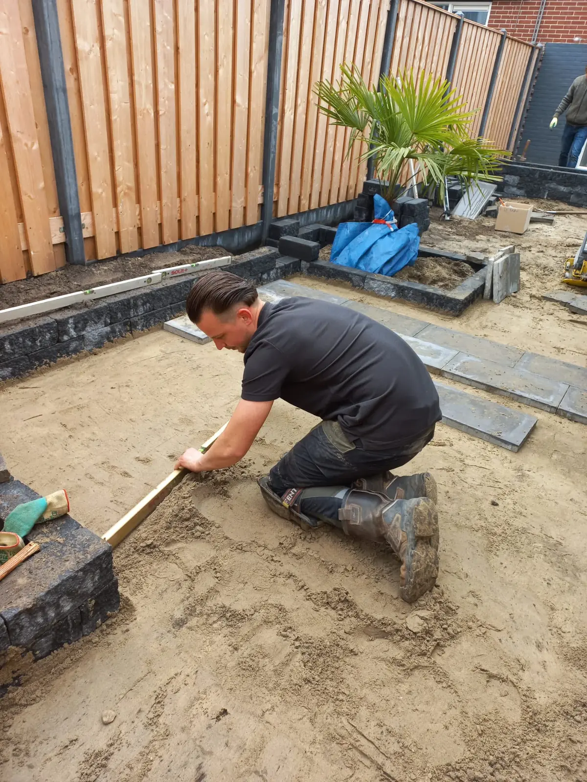 Dave Berkelder trekt het zandbed af voor een nieuw terras